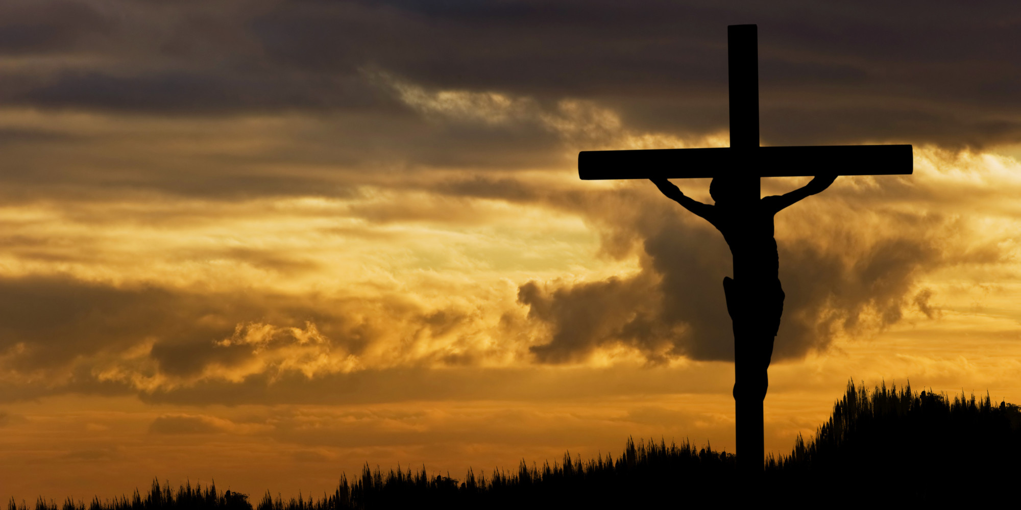 The Lord Jesus Christ appears silhouetted hanging on the cross, the sunset behind him.